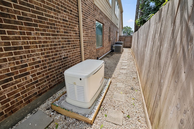 view of side of home featuring a fenced backyard and brick siding