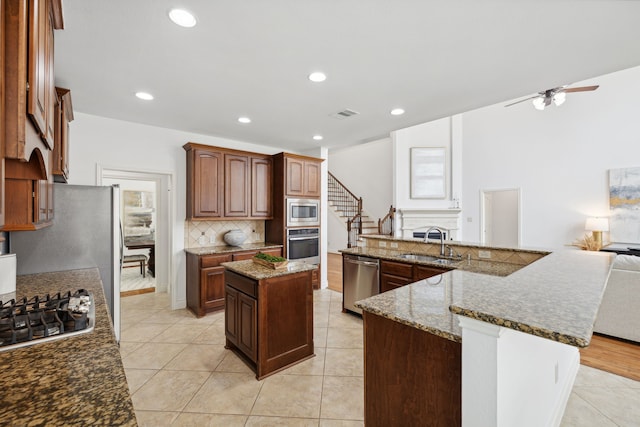 kitchen featuring a sink, visible vents, stainless steel appliances, tasteful backsplash, and a spacious island
