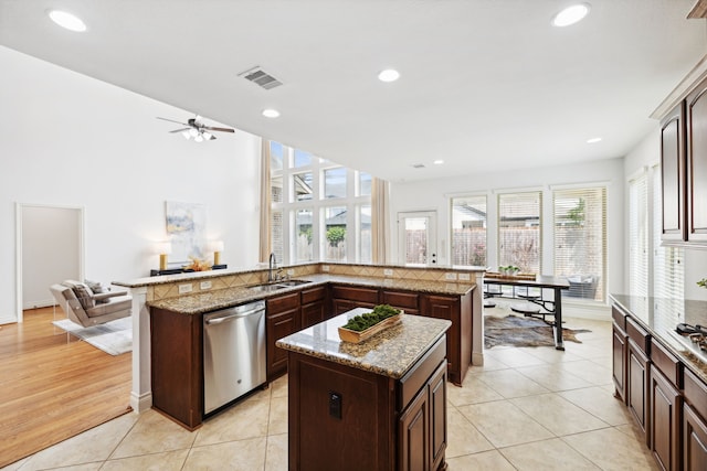 kitchen featuring visible vents, a center island, stainless steel dishwasher, a sink, and recessed lighting