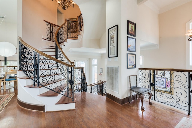 entrance foyer featuring wood finished floors, visible vents, and a high ceiling