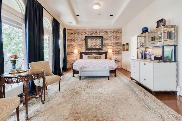 bedroom featuring visible vents, wood finished floors, and a tray ceiling