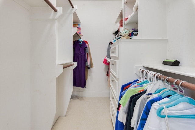 walk in closet with light colored carpet