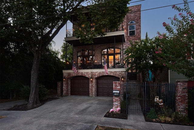 view of front of property with a balcony, driveway, brick siding, an attached garage, and fence