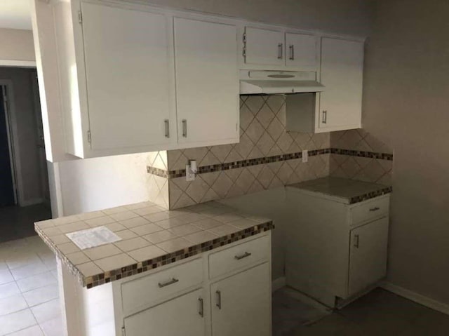 811 Buchta Rd Unit C, Angleton, TX 77515 - kitchen with white cabinets, backsplash, light tile patterned flooring, and under cabinet range hood