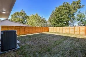 view of yard featuring a fenced backyard and central AC