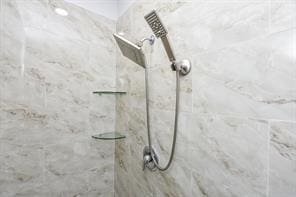 interior details featuring tiled shower