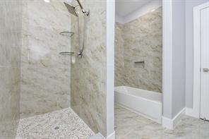 bathroom featuring a bath, baseboards, and walk in shower