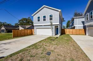 traditional-style home with an attached garage, driveway, and fence