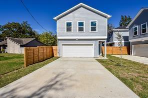 traditional-style house featuring a garage, driveway, and fence