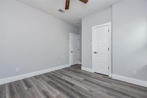 unfurnished bedroom with ceiling fan, baseboards, and wood finished floors