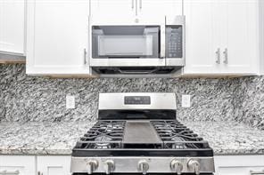kitchen featuring white cabinetry, appliances with stainless steel finishes, and tasteful backsplash