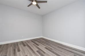 spare room with baseboards, a ceiling fan, and wood finished floors