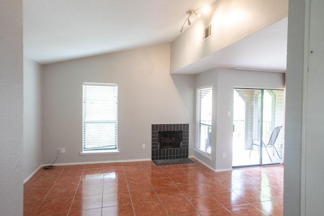 2025 Augusta Dr Unit 208, Houston, TX 77057 - unfurnished living room with tile patterned flooring, vaulted ceiling, visible vents, baseboards, and a fireplace