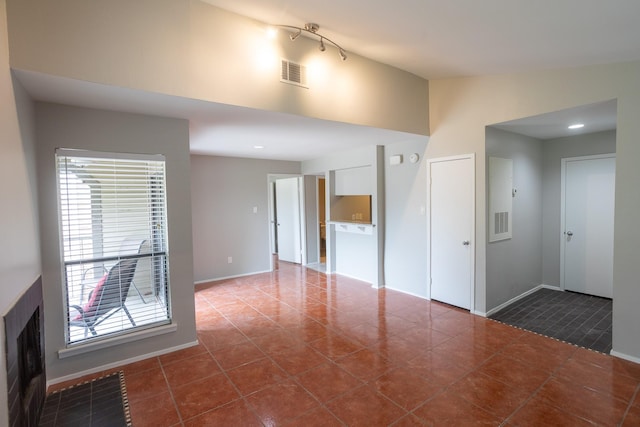 2025 Augusta Dr Unit 208, Houston, TX 77057 - unfurnished living room featuring baseboards, visible vents, and dark tile patterned flooring