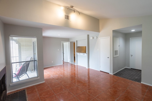 2025 Augusta Dr Unit 208, Houston, TX 77057 - unfurnished room with lofted ceiling, baseboards, visible vents, and dark tile patterned floors