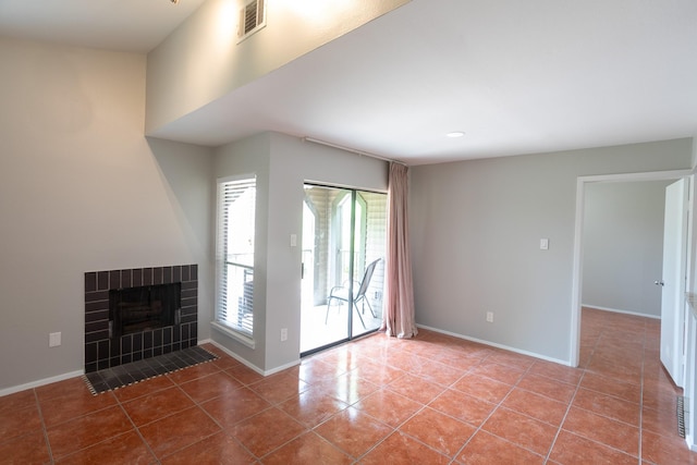 2025 Augusta Dr Unit 208, Houston, TX 77057 - unfurnished living room with visible vents, a brick fireplace, baseboards, and tile patterned flooring