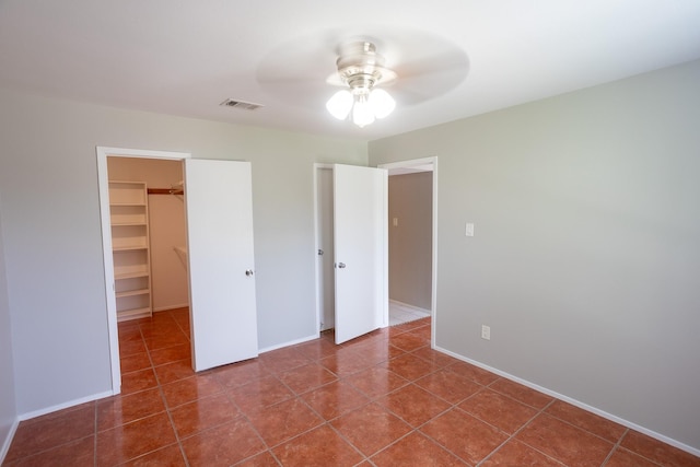 2025 Augusta Dr Unit 208, Houston, TX 77057 - unfurnished bedroom featuring a walk in closet, a closet, visible vents, and tile patterned flooring