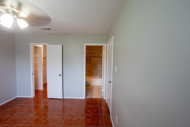 2025 Augusta Dr Unit 208, Houston, TX 77057 - unfurnished bedroom featuring a spacious closet, dark tile patterned floors, visible vents, and baseboards
