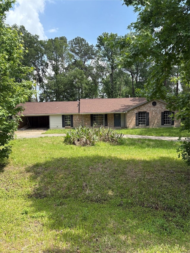 ranch-style house with driveway, a front yard, and an attached carport