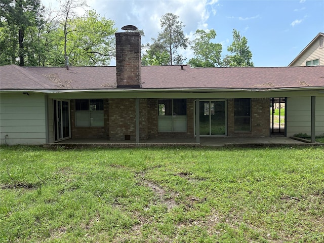 back of property featuring a patio area, a lawn, and a chimney