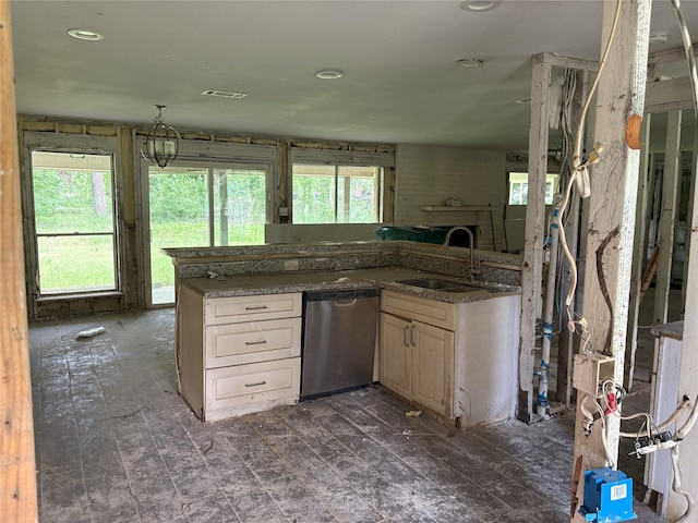 kitchen with stainless steel dishwasher, a sink, dark stone countertops, open floor plan, and visible vents