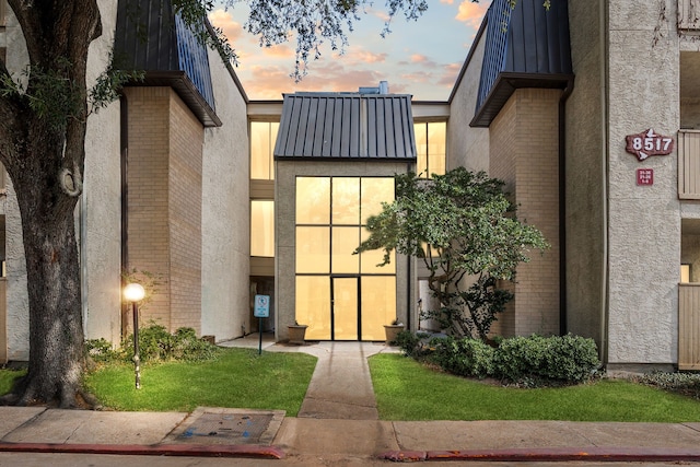 8517 Hearth Dr Unit 31, Houston, TX 77054 - view of exterior entry with brick siding, a standing seam roof, stucco siding, and metal roof