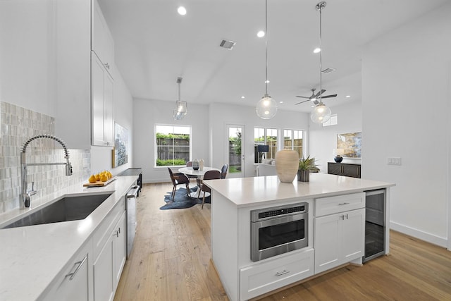 kitchen with a sink, visible vents, appliances with stainless steel finishes, wine cooler, and recessed lighting