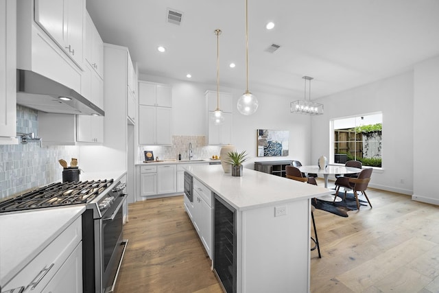 kitchen featuring a sink, visible vents, light countertops, beverage cooler, and appliances with stainless steel finishes