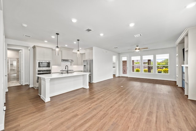 28928 Autumn Shore Dr, Fulshear, TX 77441 - kitchen featuring stainless steel appliances, open floor plan, light countertops, a ceiling fan, and baseboards