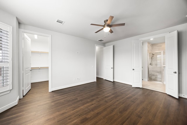 28928 Autumn Shore Dr, Fulshear, TX 77441 - unfurnished bedroom featuring dark wood-style flooring, baseboards, a spacious closet, connected bathroom, and a ceiling fan
