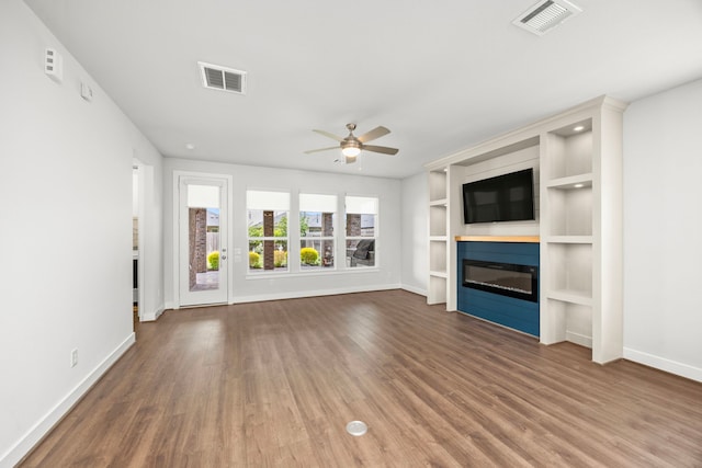28928 Autumn Shore Dr, Fulshear, TX 77441 - unfurnished living room featuring baseboards, wood finished floors, ceiling fan, and a glass covered fireplace