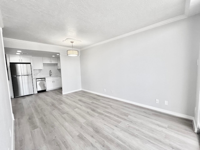 unfurnished living room featuring a textured ceiling, crown molding, and a sink
