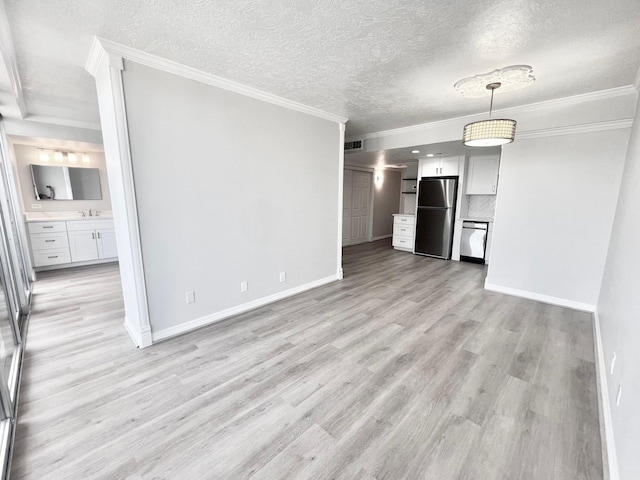 unfurnished living room with a textured ceiling, light wood-style flooring, a sink, baseboards, and ornamental molding