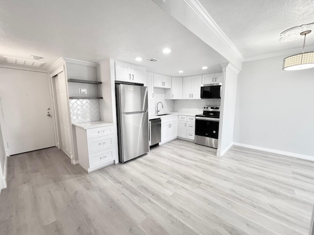kitchen with a sink, open shelves, crown molding, light countertops, and appliances with stainless steel finishes