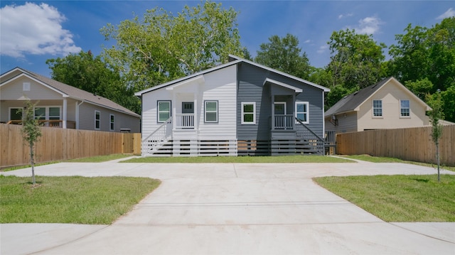 view of front of house featuring fence, driveway, and a front yard