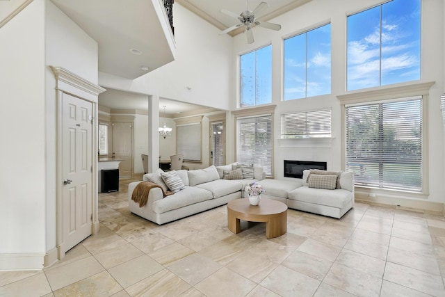 16311 Perry Pass Ct, Spring, TX 77379 - living room featuring a high ceiling, a glass covered fireplace, light tile patterned floors, a chandelier, and a ceiling fan
