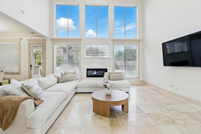 16311 Perry Pass Ct, Spring, TX 77379 - living area featuring a high ceiling, healthy amount of natural light, a high end fireplace, and baseboards