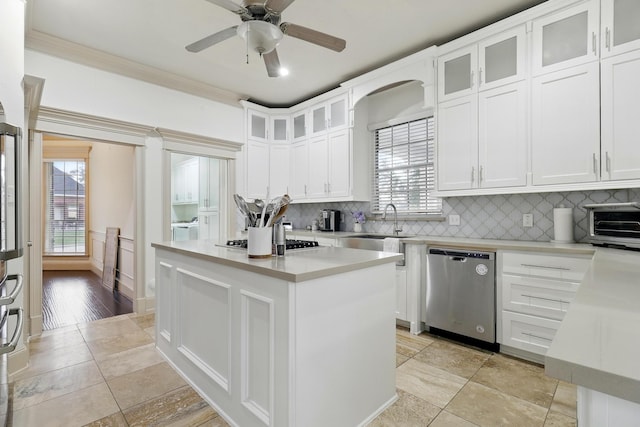 16311 Perry Pass Ct, Spring, TX 77379 - kitchen with stainless steel appliances, light countertops, decorative backsplash, a kitchen island, and a ceiling fan