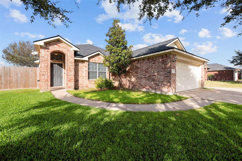 single story home with a front lawn, brick siding, fence, and an attached garage