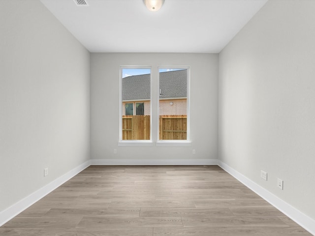 spare room with light wood finished floors and baseboards