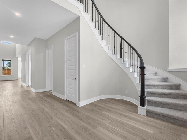 stairs with baseboards and wood finished floors