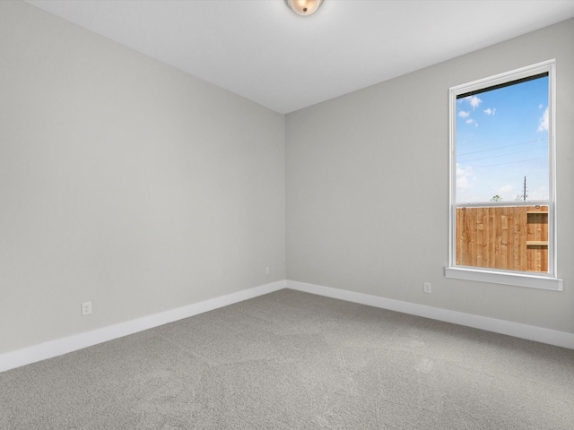 spare room featuring carpet and baseboards