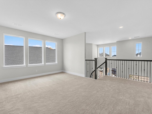 carpeted spare room featuring recessed lighting, visible vents, and baseboards
