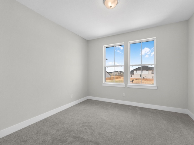 spare room featuring baseboards and carpet flooring