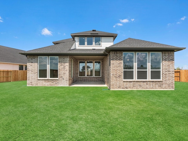 rear view of property with a lawn, a fenced backyard, and brick siding