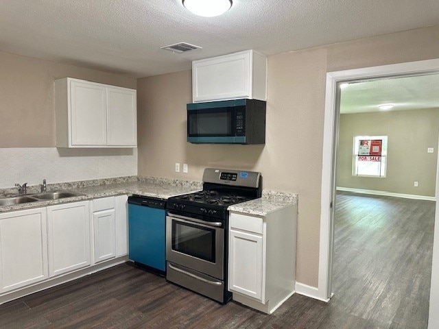 8230 Woodward St, Houston, TX 77051 - kitchen with dark wood-style floors, black microwave, dishwashing machine, visible vents, and stainless steel gas stove