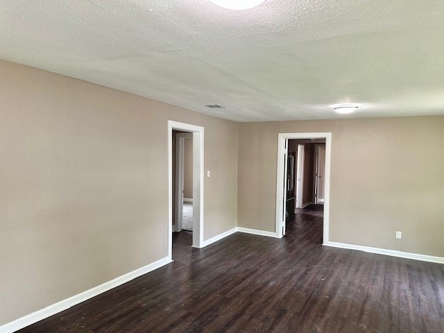 8230 Woodward St, Houston, TX 77051 - unfurnished room with dark wood-style flooring, visible vents, a textured ceiling, and baseboards