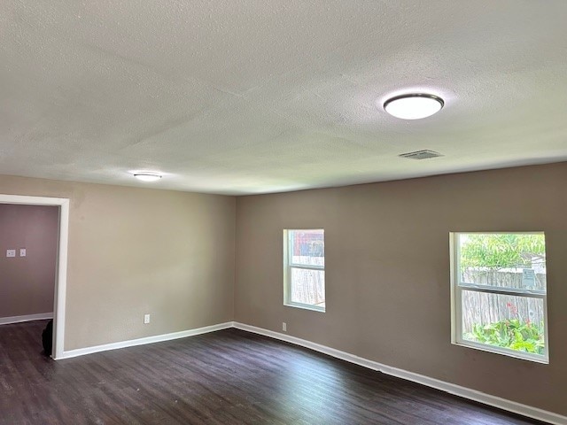 8230 Woodward St, Houston, TX 77051 - spare room with a textured ceiling, visible vents, dark wood-style floors, and baseboards