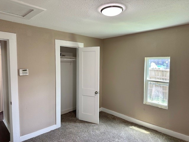8230 Woodward St, Houston, TX 77051 - unfurnished bedroom featuring a textured ceiling, visible vents, a closet, baseboards, and carpet floors