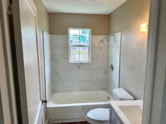 8230 Woodward St, Houston, TX 77051 - full bathroom with vanity, toilet, a textured wall, and bathing tub / shower combination